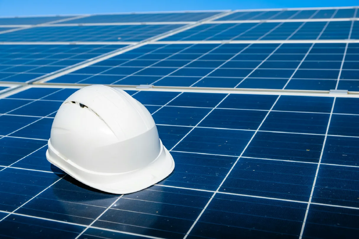 Capacete de obra sobre painéis solares