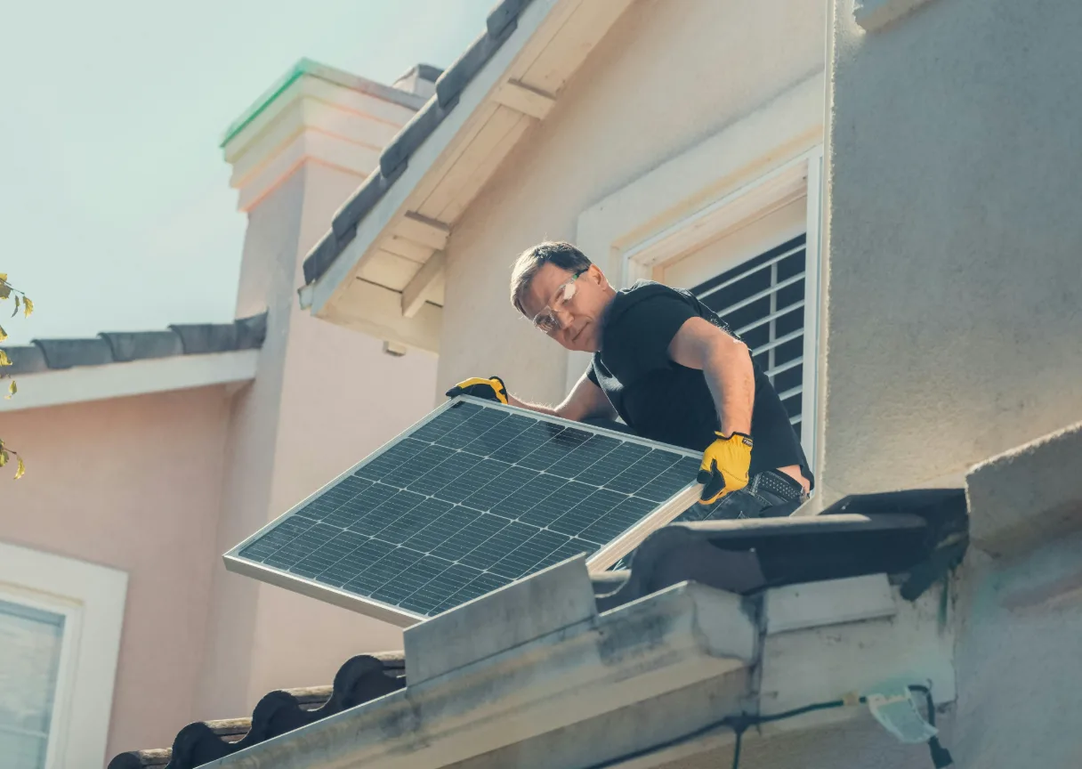 Técnico a instalar um painel solar num telhado