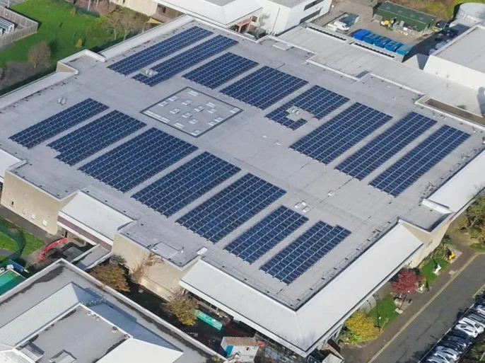 Painéis solares na cobertura plana de um edifício industrial, vistos do ar