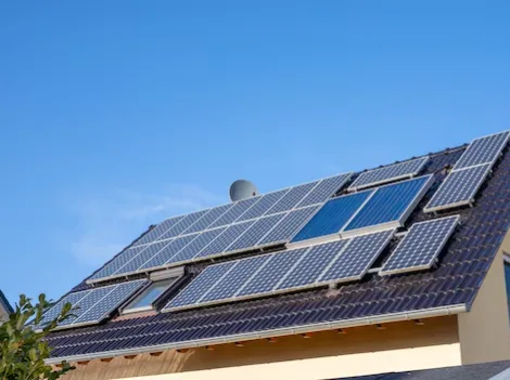 Painéis solares num telhado inclinado, com céu azul