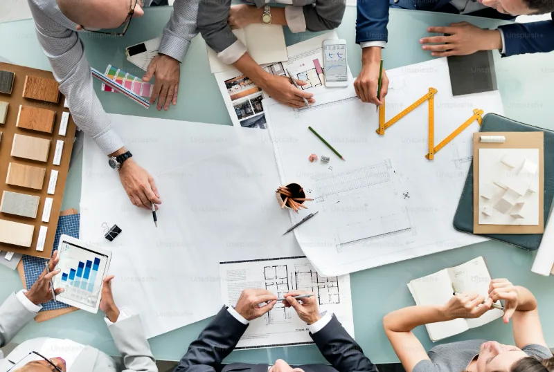 Equipa a trabalhar sobre plantas de um projeto