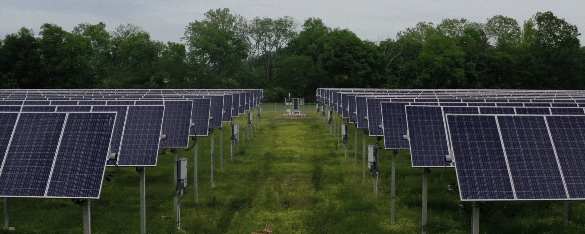 Central fotovoltaica com filas de painéis solares num campo
