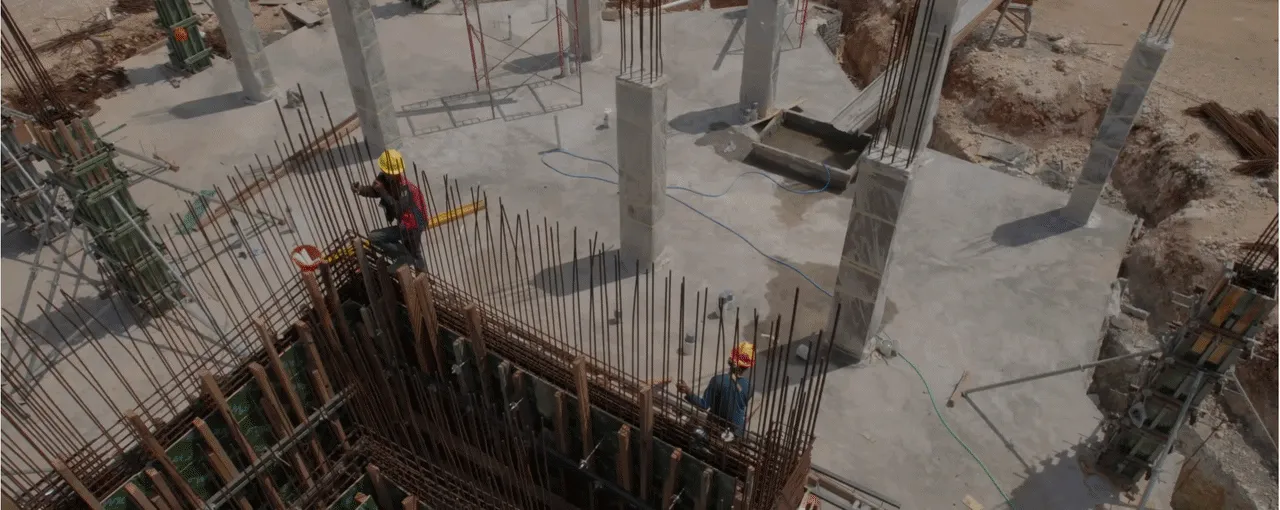 Obra com armaduras de ferro e trabalhadores